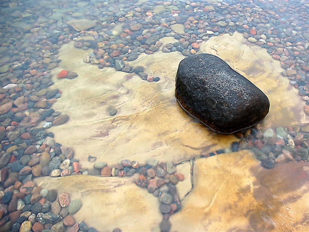 I början domineras stranden av småsten och en och annan storsten